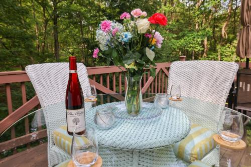 a table with a bottle of wine and a vase of flowers at Emerald Escape Lake, Theater, Game Room & More! in Long Pond