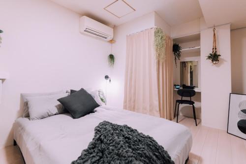 Un dormitorio blanco con una cama grande y una ventana. en Minimalist Loft 3 Namba Compact Studio and 24 hours Gym 01, en Osaka