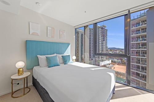 a bedroom with a large bed and a large window at Spire Residences by CLLIX in Brisbane