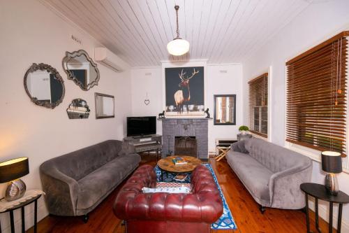 a living room with two couches and a fireplace at Bluebird Cottage in West Tamworth