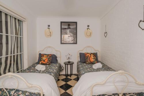a room with two beds and a window at Bluebird Cottage in West Tamworth
