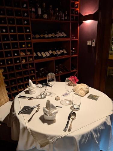 a white table with wine glasses and napkins at La Belle Tortue in Silhouette Island