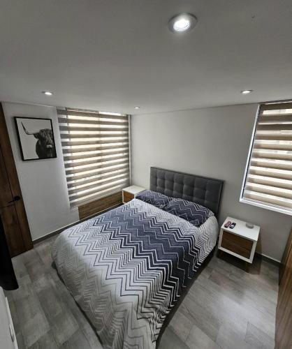a bedroom with a bed and a table in it at Modern Apartment In Cajica in Cajicá