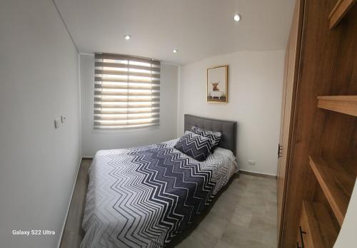 a bedroom with a bed with two pillows on it at Modern Apartment In Cajica in Cajicá