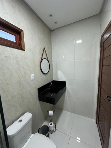 a bathroom with a white toilet and a mirror at Suítes Lampião in Piranhas