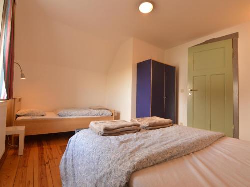 a bedroom with two beds and a green door at Group house with 3 apartment for family in Amblève