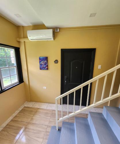 a hallway with stairs and a black door and a window at Carolina Point Resort in Crown Point