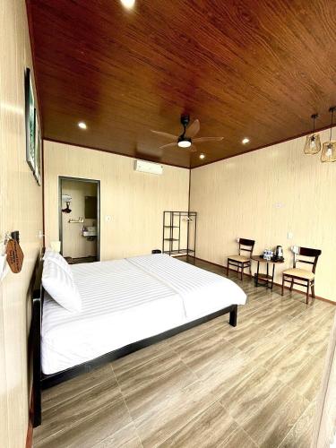 a bedroom with a large bed and two chairs at Horizon Homestay in Phong Nha