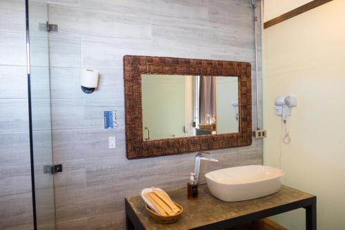 a bathroom with a sink and a mirror at AV Suites in Puerto Galera