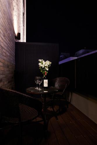 a small table with a vase of flowers on it at Urban Island Hotel Jeju in Jeju