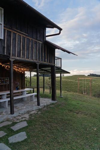 a wooden building with a bench in a field at Cabaña Peñones in Murillo