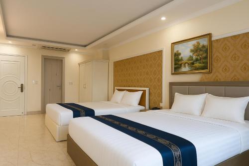 a hotel room with two beds and a painting on the wall at 希岸三好酒店 in Kon Rung (1)