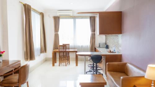 a kitchen and living room with a couch and a table at HOTEL & WISMA BINTANG JADAYAT in Bogor