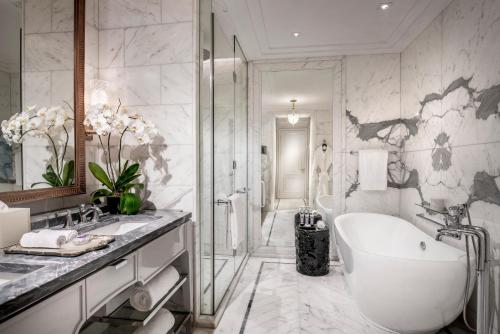 a white bathroom with a tub and a shower at Four Seasons Hotel Jakarta in Jakarta
