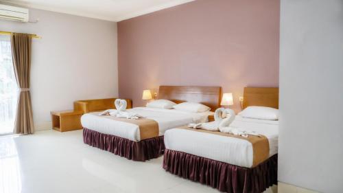 a hotel room with two beds with towels on them at HOTEL & WISMA BINTANG JADAYAT in Bogor