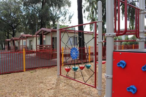 a playground with a swing at a park at Barwon River Holiday Park in Geelong