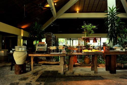 a kitchen with wooden tables with food on it at Tanjung Rhu Resort in Tanjung Rhu 