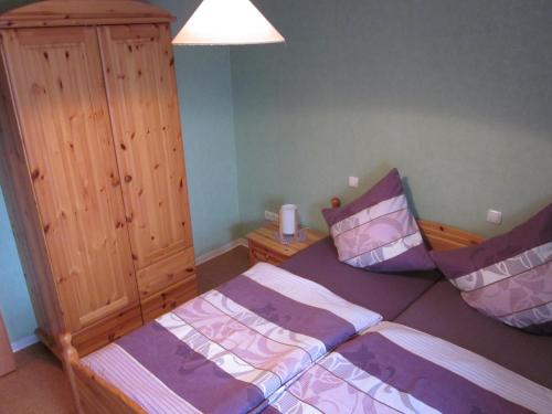 a bedroom with two beds and a wooden cabinet at Gästehaus Jüngling in Kottenborn