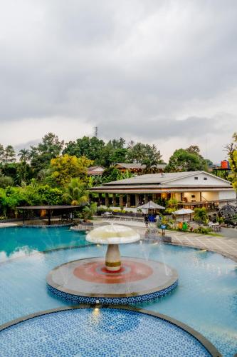 a fountain in a pool in front of a building at HOTEL & WISMA BINTANG JADAYAT in Bogor