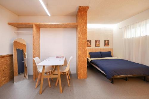 a bedroom with a bed and a table and chairs at Honeyhome in Seoul