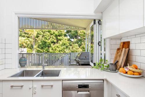 a kitchen with a sink and a bowl of fruit at Spacious Queenslander Retreat in Belgian Gardens