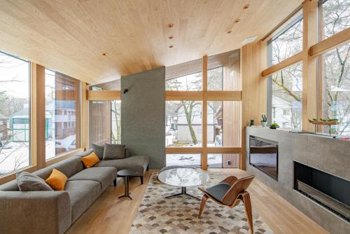 a living room with a couch and a fireplace at Kairos by the Mountain by The Hakuba Collection in Hakuba
