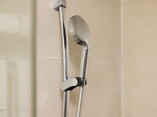 a shower head and a shower curtain in a bathroom at City Comfort Inn Shantou Daxue Road in Shantou