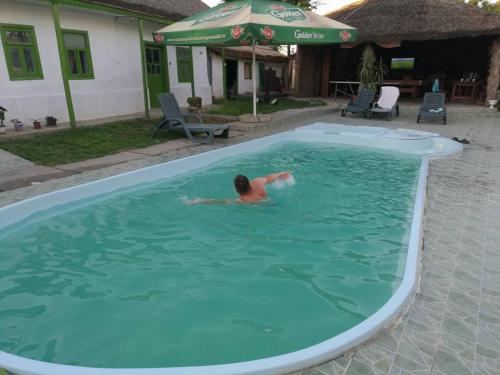 a man is swimming in a swimming pool at Pensiunea Vital in Chilia Veche