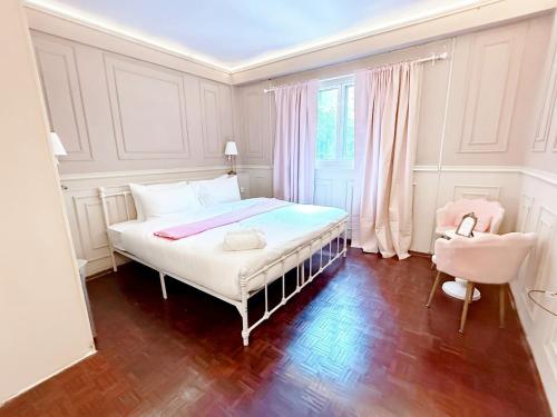 a white bedroom with a bed and a chair at X Casa Sukhumvit 11 BTS Nana -คาซ่า สุขุมวิท 11 บีทีเอสนานา in Bangkok