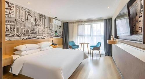 a bedroom with a large white bed and a table at City Comfort Inn Wuhan Dream Times Baotong Temple Metro Station in Wuhan