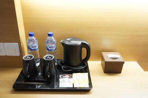 a tray with a coffee maker and two bottles of water at Front One Hotel Papua Lestari in Timika