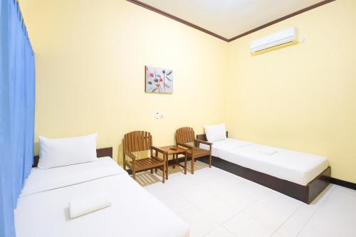 Postel nebo postele na pokoji v ubytování Wisma Kartini Syariah near Alun Alun Sidoarjo RedPartner