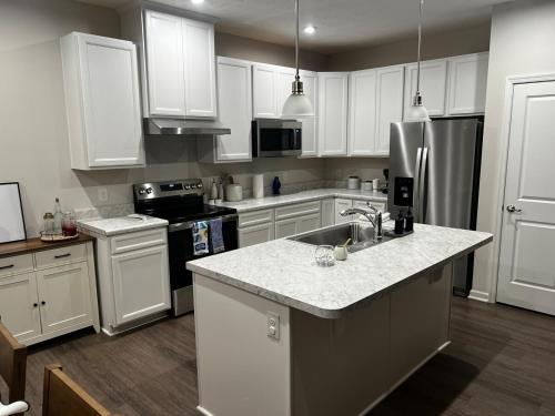a kitchen with white cabinets and a sink and a refrigerator at Modern Luxury Retreat by Oak Hill Park New 3BR in Wooster