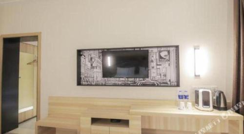 a living room with a flat screen tv on a wall at City Comfort Inn Changsha Window of the World Zhongmao City in Changsha