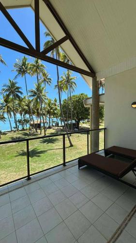a room with a view of the beach and palm trees at Mana Island Resort & Spa - Fiji in Mana Island