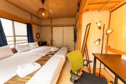 a room with two beds and a desk and a chair at Skytree Tokyo House Takasago in Tokyo