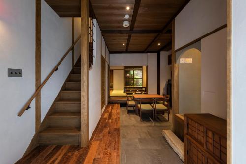 a hallway of a house with a staircase and a table at Natsume an Machiya House in Kyoto