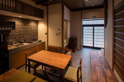 a kitchen with a wooden table and a dining room at Natsume an Machiya House in Kyoto