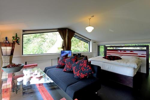 a bedroom with a bed and a couch and a window at Windsor's Breeze in Jiufen