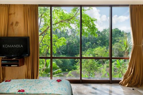 a bedroom with a large window with a view at Komaneka at Bisma Ubud in Ubud