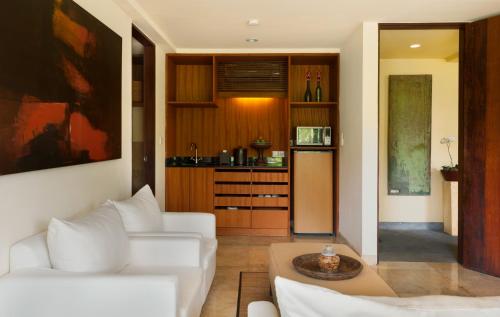 a living room with a white couch and a table at Komaneka at Bisma Ubud in Ubud