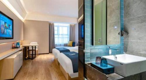 a bathroom with a bed and a sink in a room at Echarm Hotel Suzhou Shengze Oriental Extile City in Suzhou