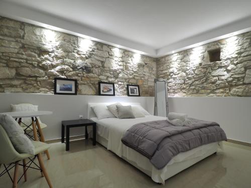 a bedroom with a bed and a stone wall at Captain Emo City Apartments in Pula