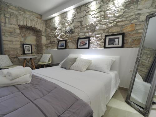 a bedroom with a large bed and a stone wall at Captain Emo City Apartments in Pula