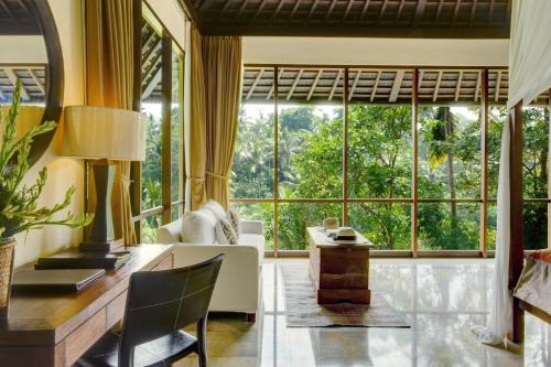 a living room with a large window at Komaneka at Bisma Ubud in Ubud