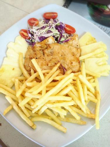 a plate of food with french fries and vegetables at Rainbow Bungalow Haadrin Koh Phangan in Haad Rin