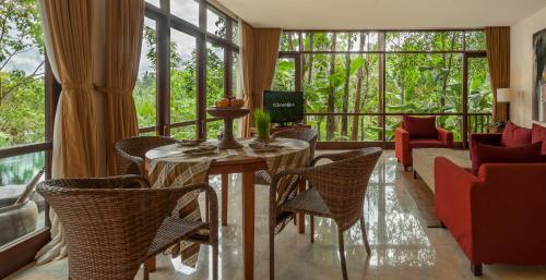 a living room with a table and chairs and a couch at Komaneka at Bisma Ubud in Ubud
