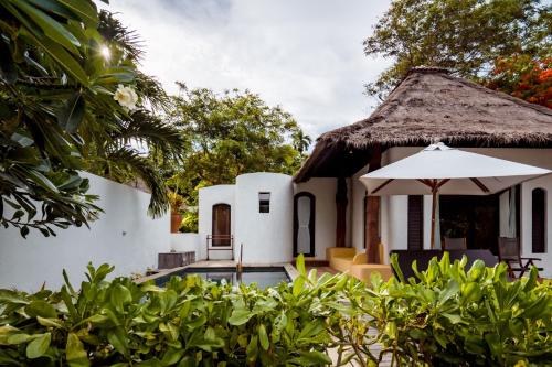 a villa with a swimming pool and an umbrella at Paradee in Ko Samed