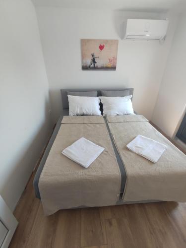 a bedroom with a large bed with two napkins on it at Villa Kally in Velika Remeta