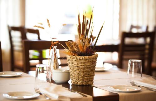a table with a vase with plants on it at Hotel Restaurante La Alhama in Medina de Pomar